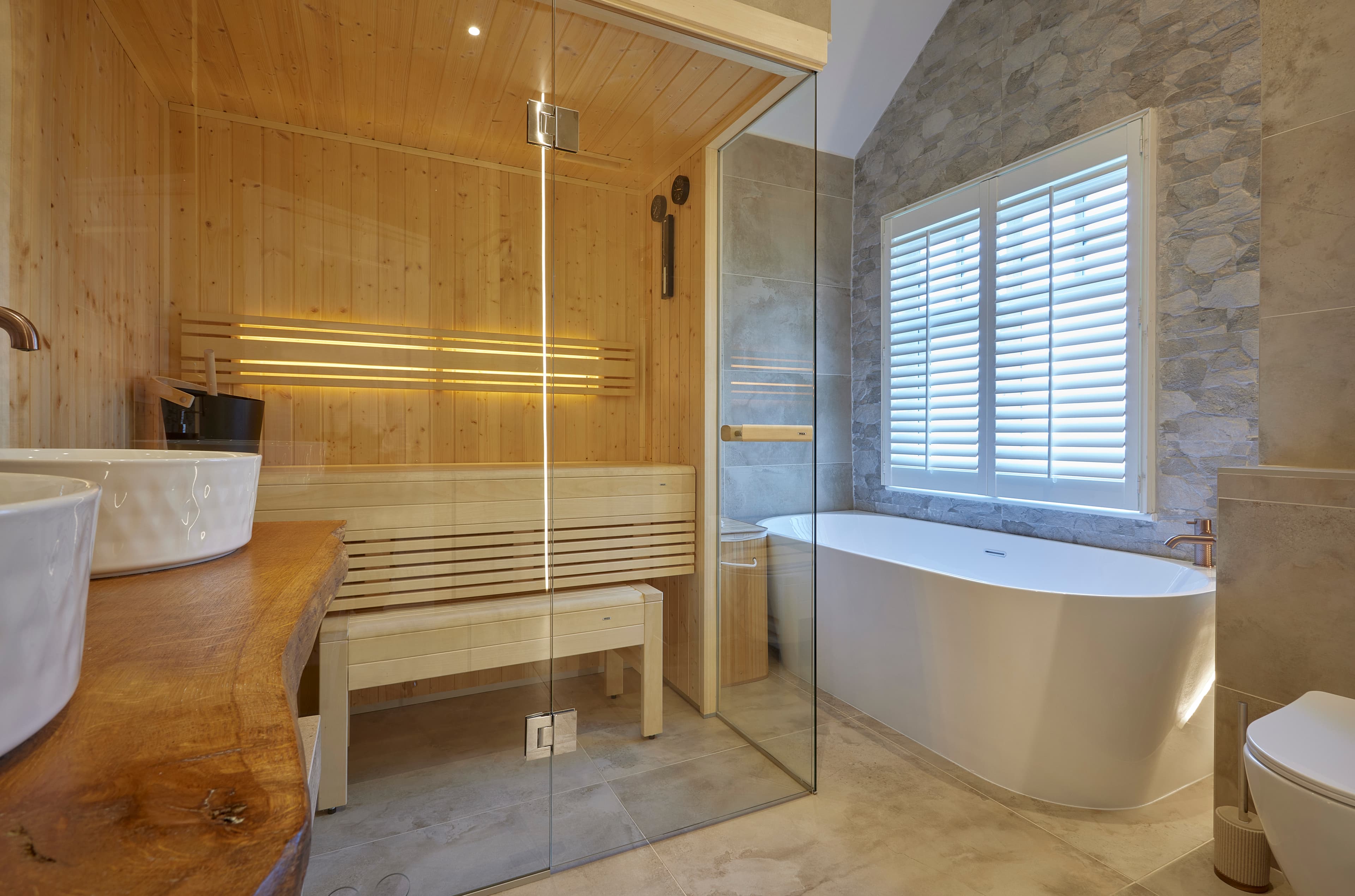 Bathroom sauna with warm stone and timber finishes